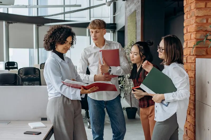 Retorio What is the Role of AI in Human Resource Management? group of people standing togther discussing 